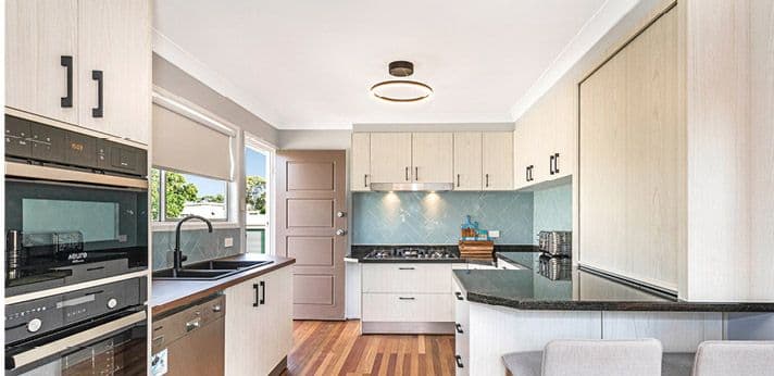 Kitchen after: white cabinets and dark benchtop