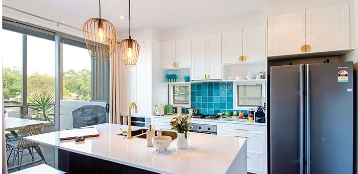 Kitchen with white benchtop and teal splashback
